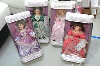 Lot of four boxed porcelain dolls in original packaging representing four birthstones with detailed Victorian-style clothing.