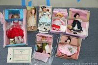 All 7 Madame Alexander collectible dolls with original boxes and certificate for limited edition porcelain doll arranged on a flat surface.
