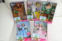 Full view of five dolls in original boxes: Cowardly Lion Ken, Tin Man Ken, Scarecrow Ken, Dorothy Barbie, and Glinda Barbie.