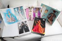 Overview photo showing five boxed Barbie dolls including Grecian Goddess, Chinese Empress, Dancing Fire, Starlight Dance, and Romantic Interlude dolls arranged on a white couch.
