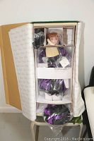 Photo of the Jan McLean Pearl doll still in box with protective cardboard inserts and packaging wrapping.