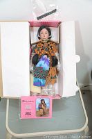Porcelain doll in original box with certificate of authenticity showing overall condition and packaging