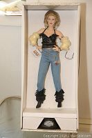 Front view of Harley Davidson Candy porcelain heirloom doll standing in original box with visible accessories and packaging.