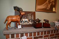 Wide photo showing the entire lot on a brick ledge with moose statue, bear plaque, and two bear statues.