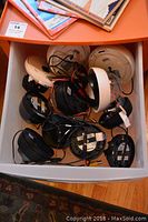 View of a drawer containing multiple surveillance cameras mostly dome style, with cables attached.