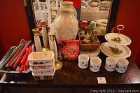 Photo of Christmas mugs, Lenox vase, candlesticks, mini loaf dishes, two-tier dessert tray, and assorted tapers on table