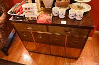 Front view of the wooden buffet with items on top removed. Shows drawer handles and lower cabinet doors.