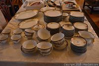 Full set of Kongo china pieces arranged on a table showing variety of plates, bowls, cups, saucers and serving dishes.