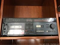 Front view of Hitachi stereo cassette tape deck in wooden shelf
