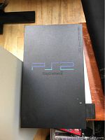 Black Sony PlayStation 2 console with PlayStation 2 logo on top, showing top view of console