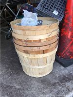 Stack of five wooden bushel baskets with wire handles