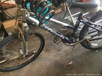 Giant Boulder SE mountain bike showing frame, pedals, front fork suspension, and rear wheel setup with rusted chain and cassette.