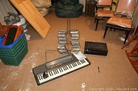 Lot showing Casio keyboard, Sony receiver, and guitar-shaped CD rack on floor