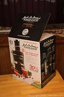 Front corner view of the unopened original box showing the juicer and features on the packaging.
