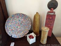 Wide view of all five ceramic decorative pieces including large floral plate, two tall vases, red-pink sculpture, and small box with ceramics