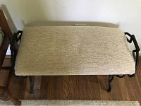 Top view of the beige upholstered bench with black decorative metal frame.