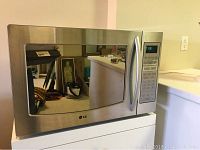 Front view of LG microwave convection oven showing stainless steel door with large window and handle.