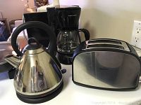 Front view of cordless kettle, drip coffee maker and 2-slice toaster on counter