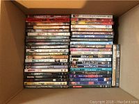 Top down view of DVDs in box showing titles such as Counterfeiters, American Love, Meet Bill, Wildcats, Fatal Error, Martian Child and others.