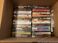 Top-down photo showing a box full of DVDs stacked vertically. Titles visible include Homeland, The Killing, Night Owl, Sugar & Spice, One Time, Moulin Rouge, Dirty Sexy Money, Touch, Counselor, and others.