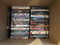 Photo showing DVDs stacked in box, titles visible such as 'Aunt Agatha's Apartment', 'Sex the Single Mom', 'Broken English Vietnam', and others.