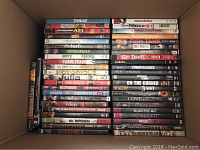 Top view of DVDs in a box with mixed movies and TV titles, showing three rows stacked to display titles.