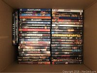 Top-down view of a box filled with DVDs showing movie titles including Heartlands, The Simple Life, Nil by Mouth, Powder Blue, among others.