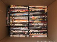 Boxes filled with assorted used DVDs showing titles like Tiptoes, Miranda, Past Perfect, Spanglish, Satin Rouge, Lost Junction, Killer Gorilla, The X-Files Fight The Future, and many more.