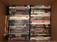 Full box view containing a large number of DVD cases with varied movie genres and creators.