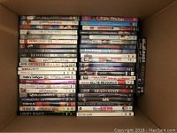 Box filled with assorted used DVDs showing titles such as The Ring Virus, Perfect Opposites, Antitrust, A Fond Kiss, Being Light, Dr. Quinn Medicine Woman, Beyond the Sea.