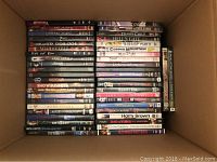 Top down photo showing dozens of DVDs stacked side by side in a box, titles include Wishmaster, Vampire Stories, Soulkeeper, Dark Heaven, Amityville, Show Business.