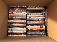 Box view showing DVDs stacked with titles visible, including Mad Men seasons, Dexter season 4, The Bling Ring and others.
