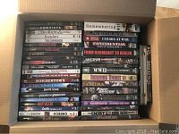 Top view of DVD lot showing a variety of movie and documentary titles arranged in a box.