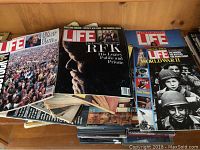 Photo showing several Life magazines with prominent covers including RFK and WWII imagery.