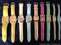 Top view of 9 Joan Rivers wristwatches with colorful leather bands, showing different colors and watch face styles.