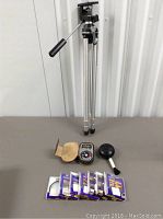 Full view of tripod, exposure meter with black bulb, and six Hoya filter/lens packages on table