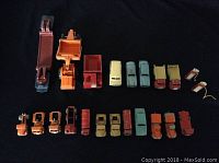 Top-down view of 19 assorted diecast vehicles arranged in three rows including trucks, cars, and trailers.