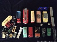 Assortment all items laid out on black surface showing vehicles and loose accessories