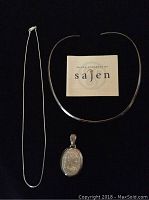 Photo of thin silver chain necklace, silver choker, mother of pearl pendant, and Sajen brand card.