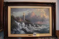 Full front view of the framed lithograph showing ornate dark brown wood frame, mat border, and entire seascape scene.