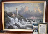 Full view of framed lithograph on floor with Certificate of Authenticity and documentation beside it