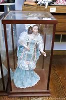 Full view of the Maryse Nicole porcelain doll in a wooden and glass case, showcasing the Victorian-style dress and lace detailing.