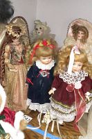 Overview photo showing the five porcelain artist dolls arranged together in a shelf.