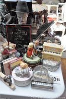 Photo showing various music boxes, cat figurines, two children figurine, and Phantom of the Opera themed item.