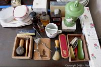 Top view of the collection showing colognes, shaving brushes, shoe horns, porcelain items, and grooming tools.