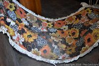 Side view of hammock showing colorful floral fabric and fringed edges.
