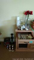 Wide view of assortment of vases on cabinet and candles on floor and in drawer