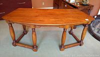 Wooden desk top surface and turned legs from an angle, showing finish and condition.