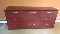 Front view of the nine-drawer IKEA style lateral filing cabinet showing dark wood finish and silver handles.
