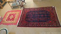Both area rugs displayed side by side on carpeted floor